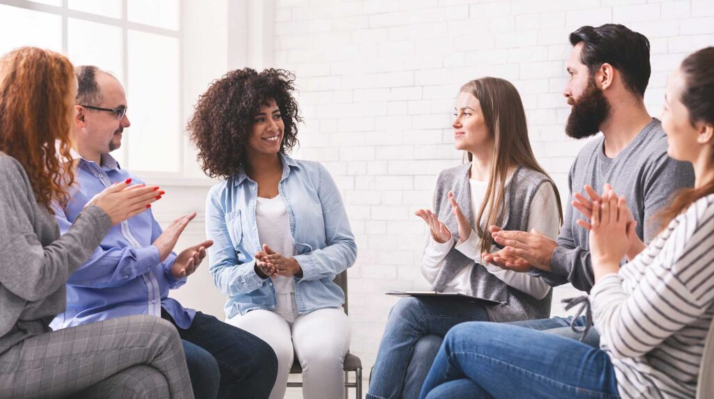 people applauding to themselves at therapy session in rehab