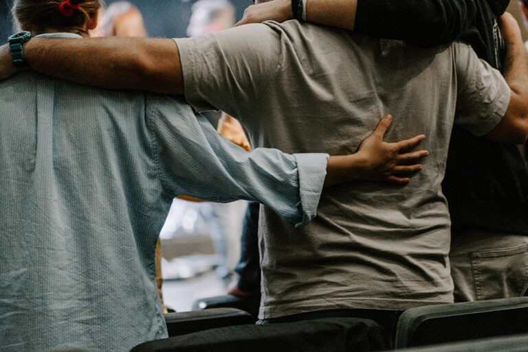 Male family members giving side embraces during a family therapy session