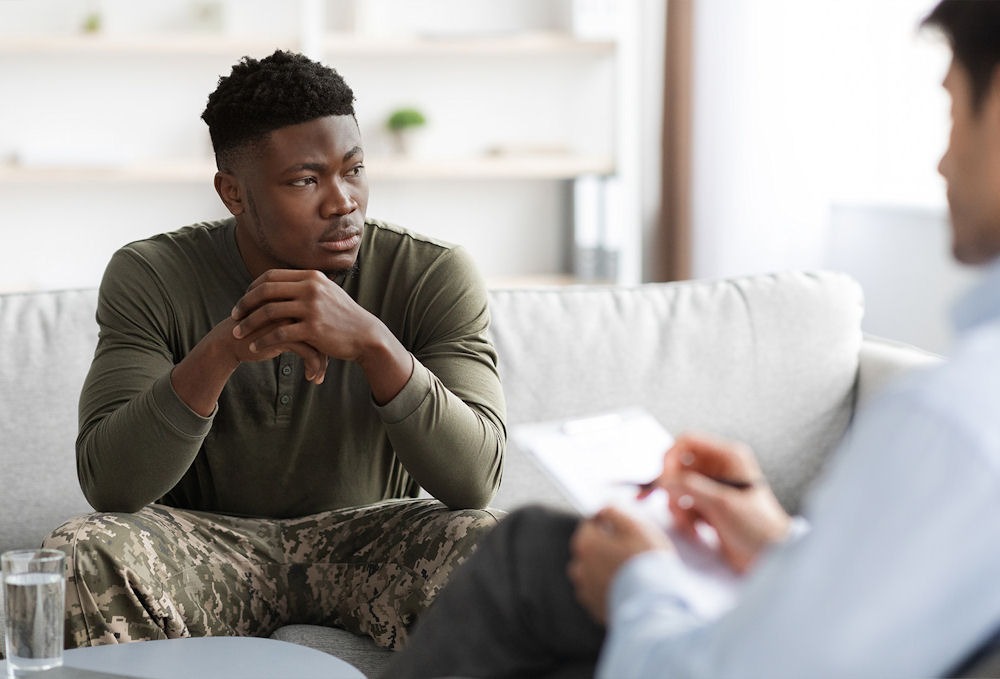 Man in military fatigues talking with therapist about depression