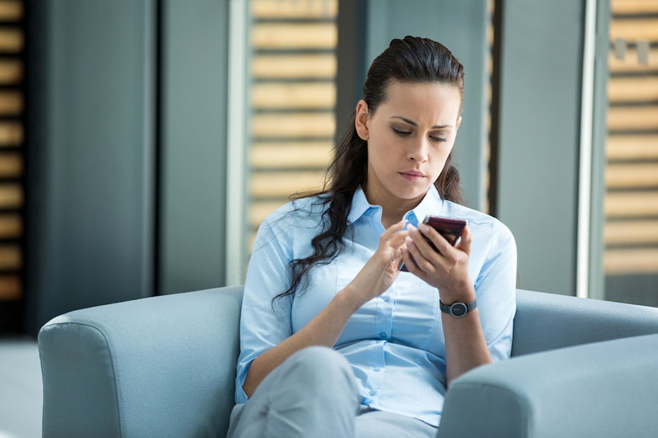 Woman looking up addiction coverage options on her phone