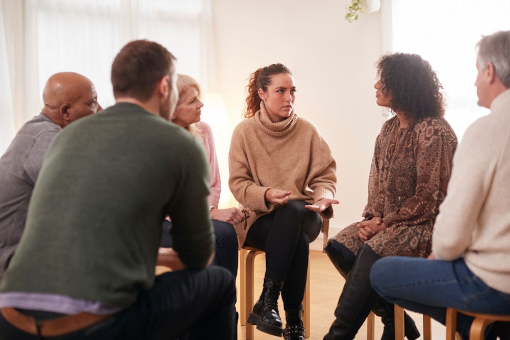 Woman in sweater describes personality disorder and addiction to mixed gender support group