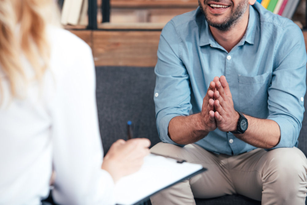 man in therapy speaking with counselor
