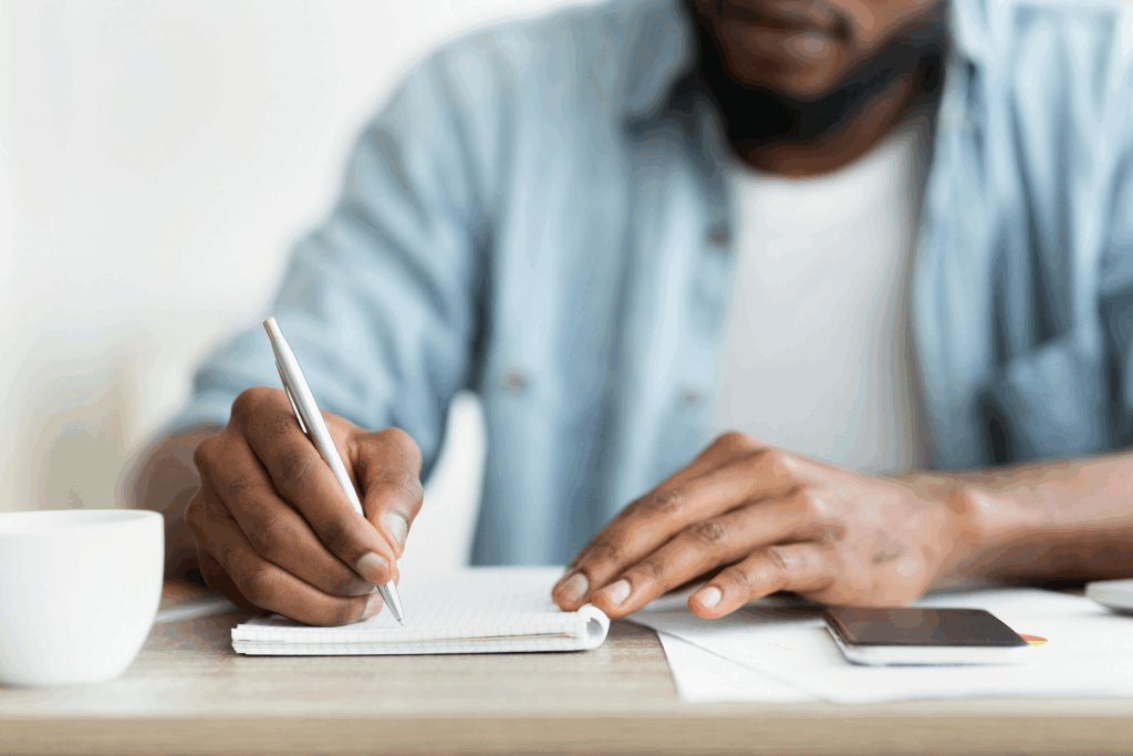 Person writing in a relapse prevention plan journal as part of their recovery process.