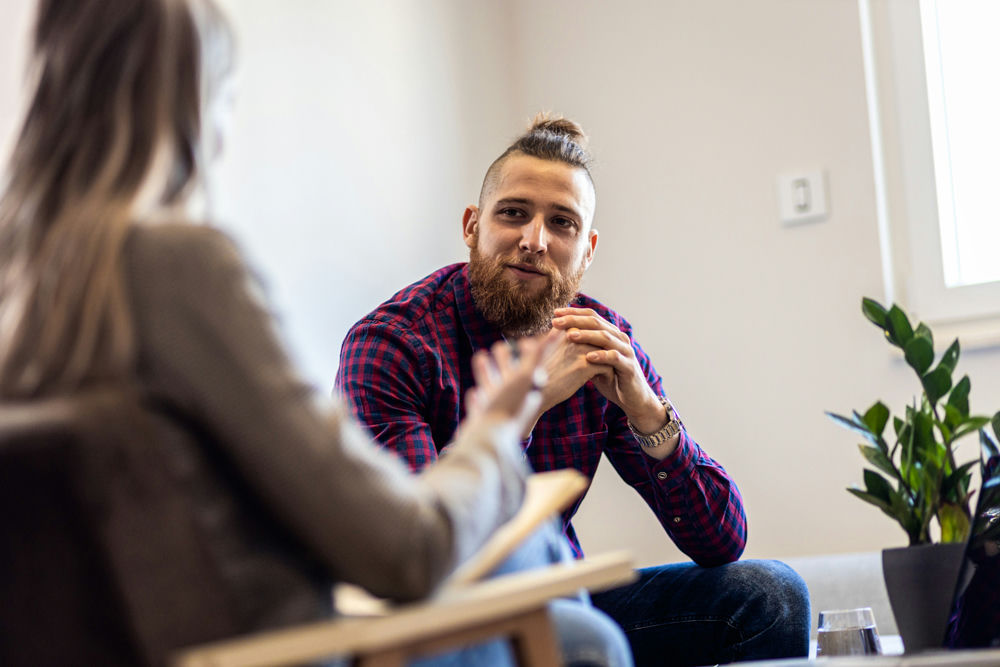 man in therapy listening to counselor discuss IOP treatment