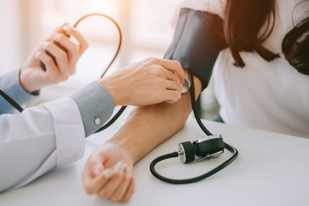 Adult having blood pressure measured while discussing the health effects of alcohol consumption with a healthcare provider.